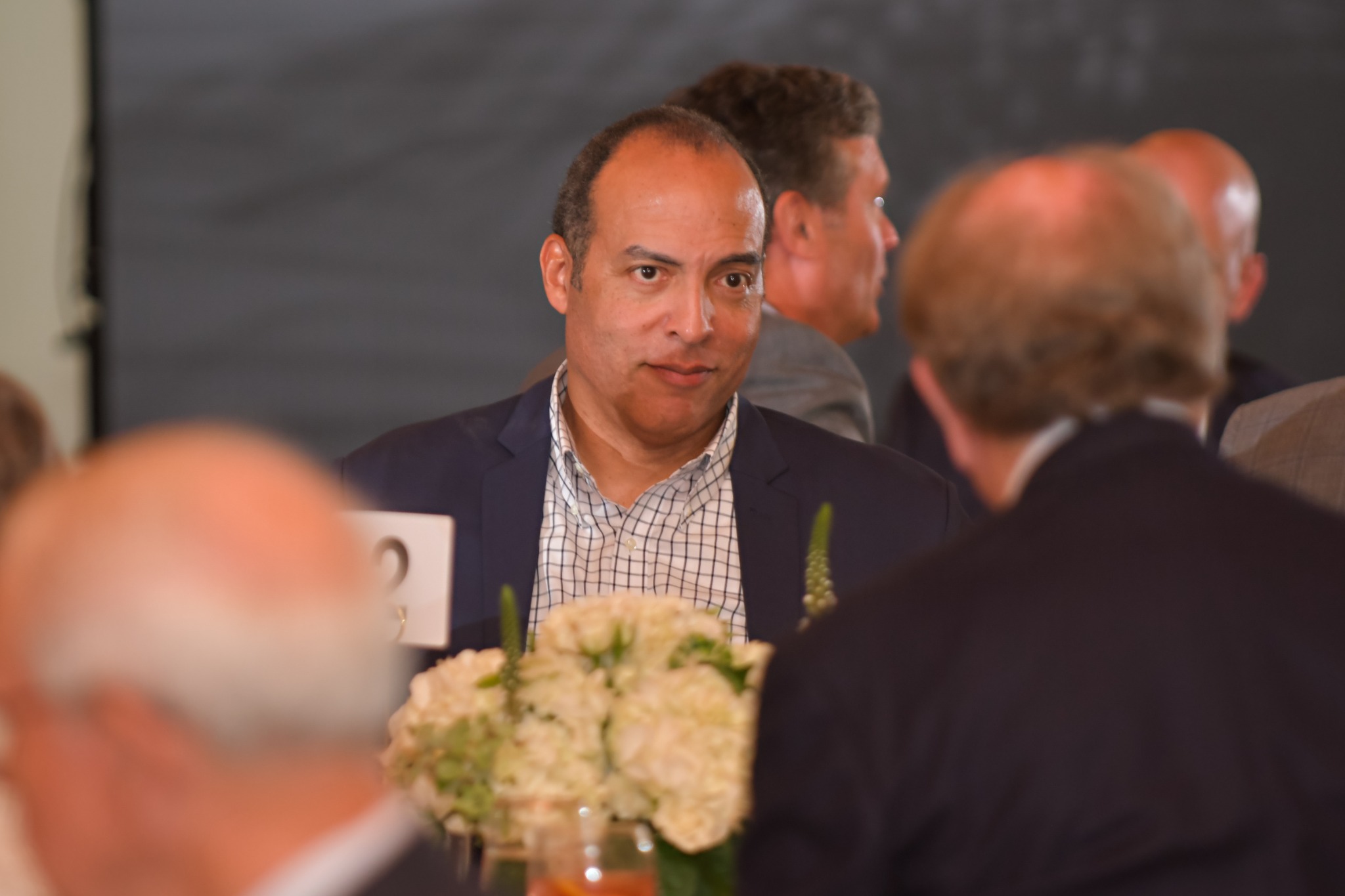 Michael Boulware Moore engaged in conversation at a luncheon